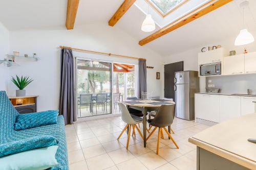une cuisine et un salon avec une table et des chaises dans l'établissement Le 113 Dunes - Jardin parking proche plage, à Saint-Jean-de-Monts