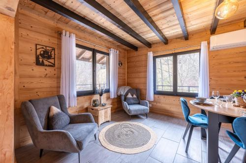 - un salon avec des murs en bois, une table et des chaises dans l'établissement Chalet le Fier - Vue montagnes proche d'Annecy, à Thônes