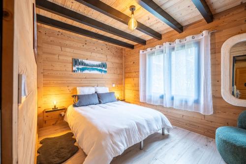 una camera da letto con un letto in una stanza di legno di Chalet le Fier - Vue montagnes proche d'Annecy a Thônes
