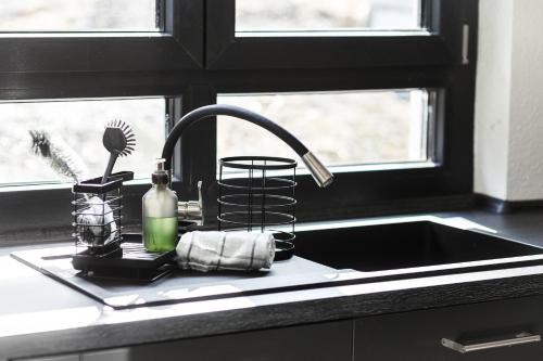 a kitchen sink with aaucet next to a window at NEU Inner Light, mit privater Sauna und schnellen Internet, Luxuriöses Ferienhaus im Harz in Altenau