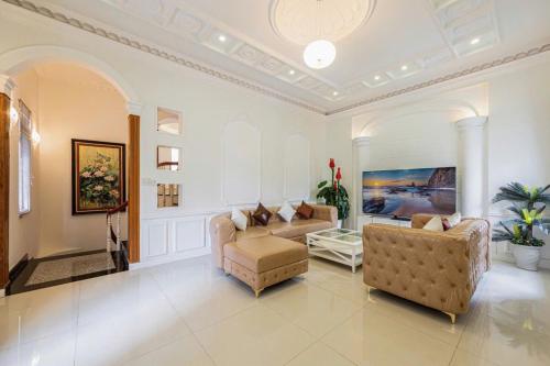a living room with two chairs and a couch at Villa La Rose Blanc Thảo Điền in Ho Chi Minh City