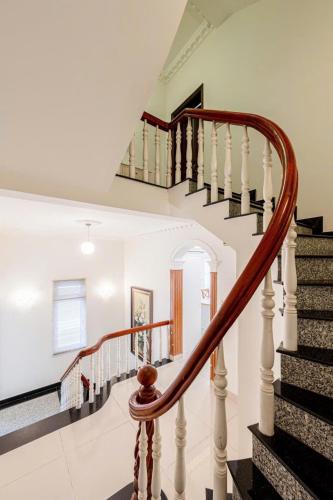 a spiral staircase in a home with white walls at Villa La Rose Blanc Thảo Điền in Ho Chi Minh City