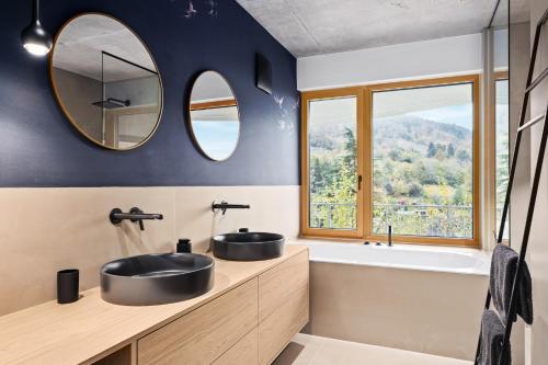 a bathroom with two sinks and a tub and a mirror at Coalhouse Pfalz in Sankt Martin