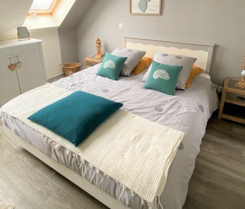un grand lit avec des oreillers bleus dans une chambre dans l'établissement Ty Caïrn - Porte du Crouesty, à Arzon