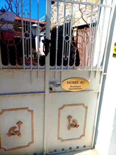 a gate with two monkeys on it with a home aid sign at Home4U Κερατέα apt3, just 17Km from airport in Keratea