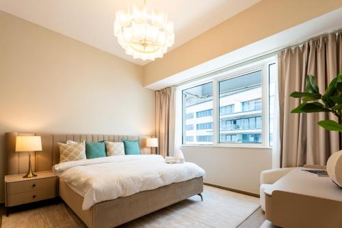 a bedroom with a bed and a large window at Sustainable Stylish Mayan 1 Bedroom - Yas Island in Abu Dhabi