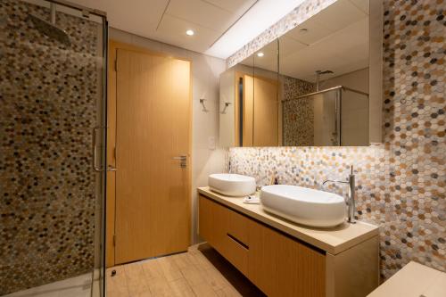a bathroom with two sinks and a mirror at Sustainable Stylish Mayan 1 Bedroom - Yas Island in Abu Dhabi