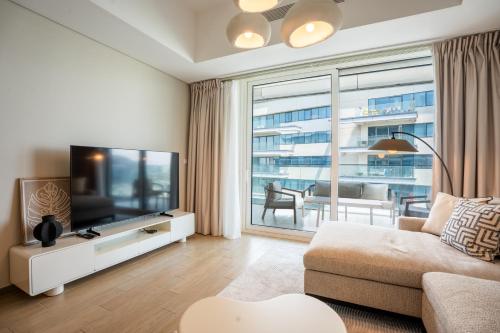 a living room with a couch and a television at Sustainable Stylish Mayan 1 Bedroom - Yas Island 809 Mayan 4 in Abu Dhabi