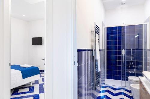 a blue and white bathroom with a shower and a toilet at Lemon Flats Sorrento 2 in Sorrento