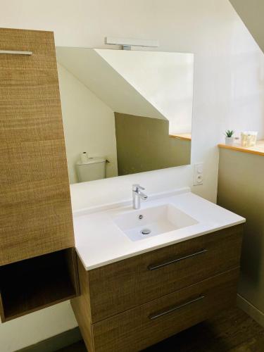 une salle de bain avec un lavabo et un miroir dans l'établissement La Maison du Cordonnier, à Gouesnou
