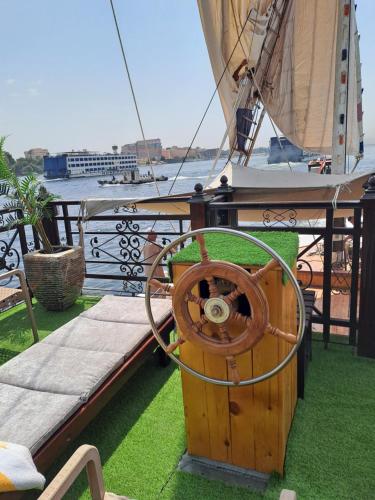 a wooden boat with a steering wheel on the grass at Saphir Dahabiya luxury sailing boat Nile cruise Every Saturday from Luxor 4 or 7 nights in Luxor