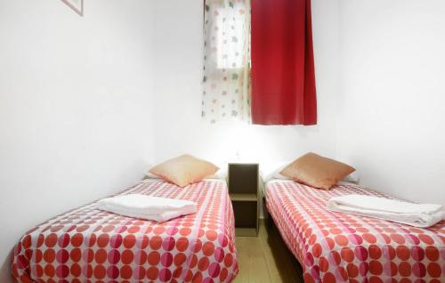 two beds in a room with red and white sheets at Lovely Apartment In Puntone Di Scarlino in Puntone di Scarlino