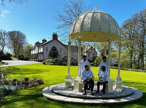 a group of people sitting in a gazebo in a yard at Plas Dinas Country House in Caernarfon
