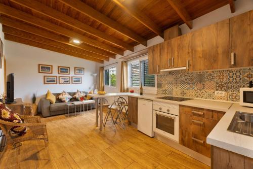 a kitchen with wooden cabinets and a living room at Casa Carlos - Vista Mar in Hermigua