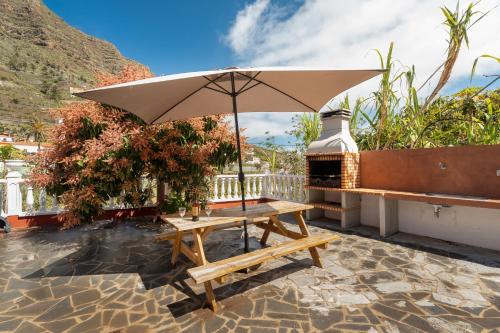 a picnic table with an umbrella on a patio at Casa Carlos - Vista Mar in Hermigua