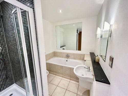 a bathroom with a tub and a sink and a shower at City Centre Apartment, Nr West Quay, Free Parking in Southampton