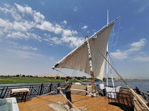 a man standing on a boat with a sail at Saphir Dahabiya luxury sailing boat Nile cruise Every Saturday from Luxor 4 or 7 nights in Luxor