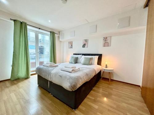 a bedroom with a large bed and a large window at City Centre Apartment, Nr West Quay, Free Parking in Southampton