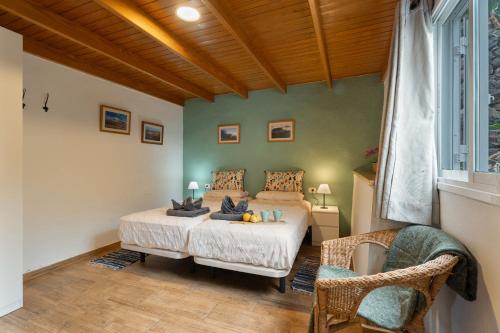 a bedroom with a bed and a chair at Casa Carlos - Vista Mar in Hermigua