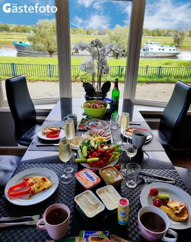 a table with plates of food and glasses of wine at SUNBI-Chalet in Lathum