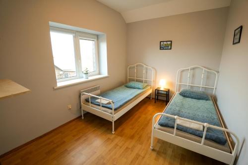 a bedroom with two bunk beds and a window at 6 vietų namelis ant ežero kranto in Sudervė