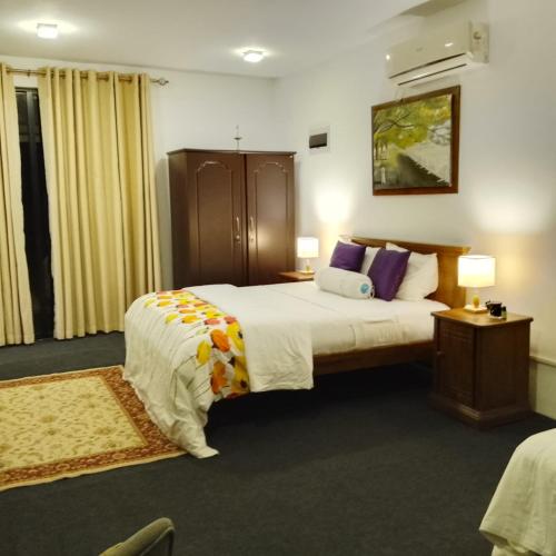 a hotel room with a large bed and two lamps at High Rise in Kandy