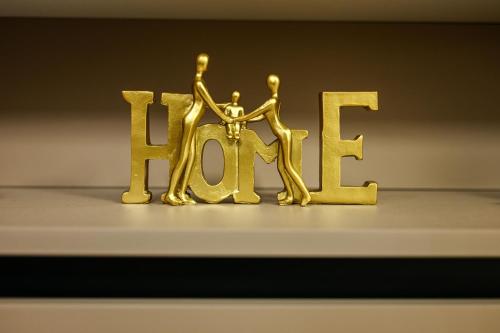 a gold sign that says hear with a person in it at Apartmani EMA SL in Vranje