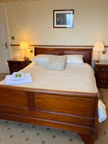 a bedroom with a large wooden bed with two lamps at Albright Hussey Manor in Shrewsbury