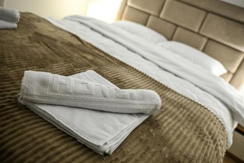 a white towel sitting on top of a bed at Apartmani EMA SL in Vranje