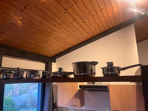 a shelf with pots and pans on top of a stove at Franziska's Ferienwohnung - Die Unterkunft in ruhiger Lage direkt am Wald in Marburg an der Lahn