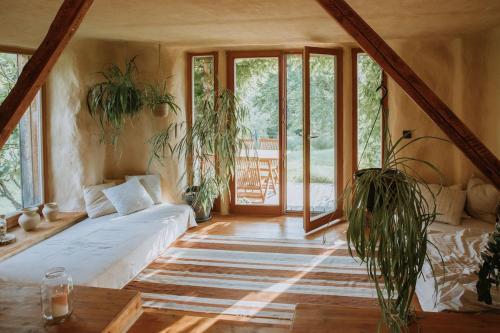 a living room with potted plants and a couch at Private Eco Cottage in Nature in Šulinci