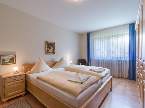 a bedroom with a large bed and a window at Ferienwohnanlage Oberaudorf D 2 mit Hallenbad und Sauna in Oberaudorf