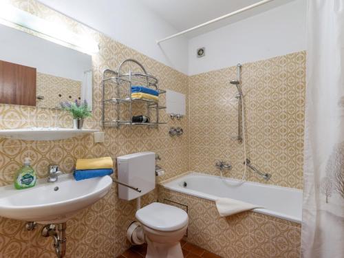 a bathroom with a sink and a toilet and a tub at Ferienwohnanlage Oberaudorf D 2 mit Hallenbad und Sauna in Oberaudorf
