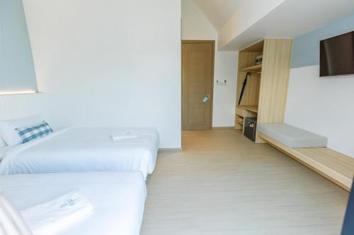 a hotel room with two beds and a flat screen tv at Sea Side at Ao Nang Landmark Night Market Krabi in Ban Khlong Haeng