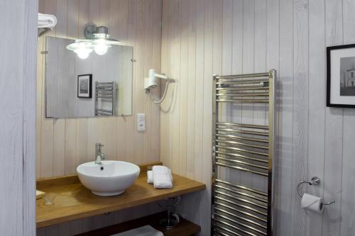 La salle de bains est pourvue d'un lavabo et d'un miroir. dans l'établissement Maison de Mézos, à Mézos