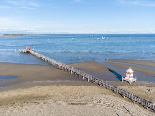 a pier leading into the water with a lighthouse at La terrazza sul faro in Lignano Sabbiadoro
