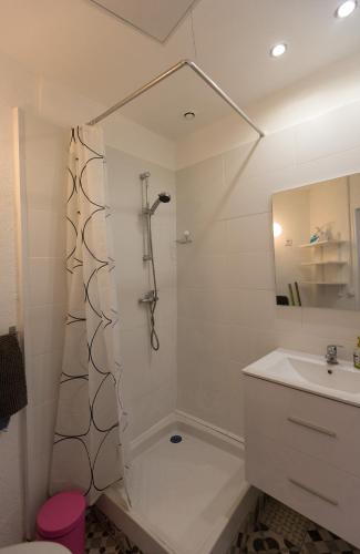 une salle de bain blanche avec une douche et un lavabo dans l'établissement Le Petit Longchamp, à Marseille