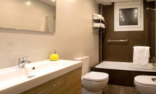 y baño con lavabo, aseo y bañera. en Apartamentos Amaiur en Estella