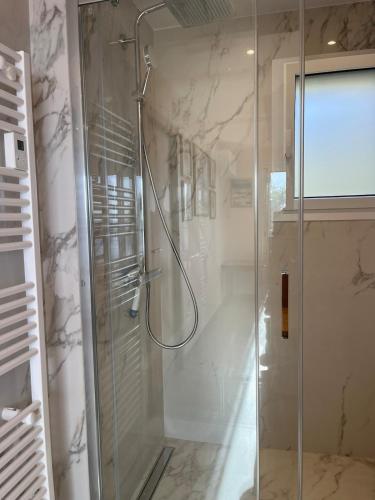 une douche avec une porte vitrée dans une salle de bain dans l'établissement La plage de Saint Clair à pied, au Lavandou