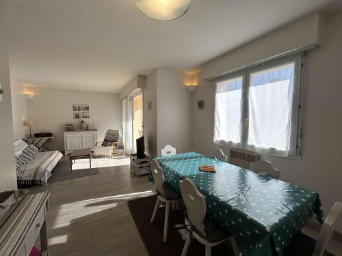un salon avec une table et un tissu de table vert dans l'établissement Location Vacances 3P 6 Couchages - Saint-Jean-de-Monts - FR-1-224C-439, à Saint-Jean-de-Monts