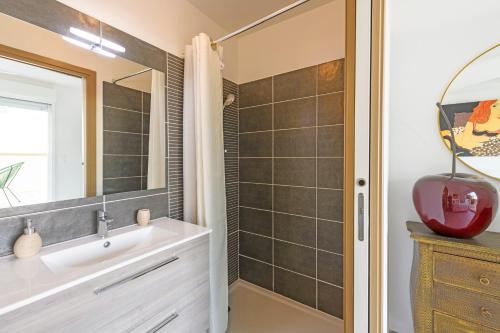 une salle de bain avec un lavabo et un miroir dans l'établissement Le Joyau Nîmois - Grande terrasse avec parking, à Nîmes