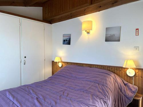 - une chambre avec un lit violet et deux lampes dans l'établissement Charmante maison avec mezzanine, piscine chauffée, à 600m de la mer - Bretignolles-sur-Mer - FR-1-224A-586, à Bretignolles-sur-Mer