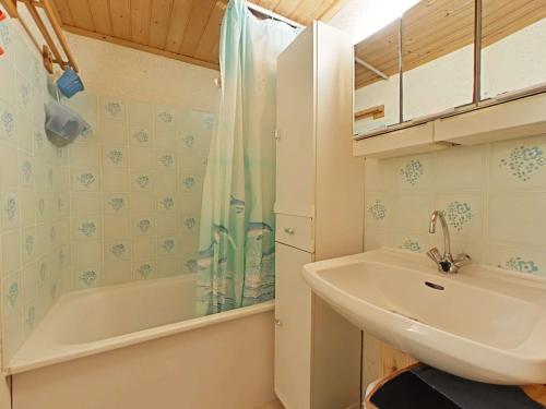 une salle de bain avec un lavabo et une baignoire dans l'établissement Charmante maison avec mezzanine, piscine chauffée, à 600m de la mer - Bretignolles-sur-Mer - FR-1-224A-586, à Bretignolles-sur-Mer
