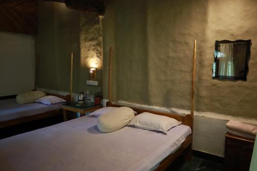 a bedroom with two beds and a mirror on the wall at Backpackers eco village in Japur