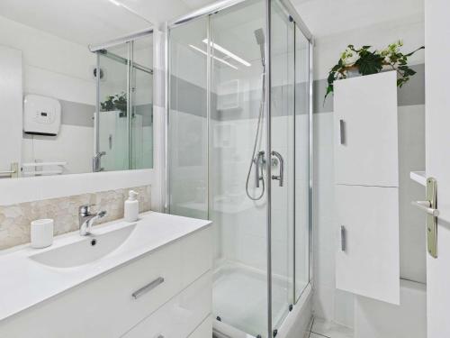 une salle de bain blanche avec une douche et un lavabo dans l'établissement Appartement cosy 2 pièces, 4 pers, 30m plage, ascenseur - FR-1-423-203, au Grau-dʼAgde
