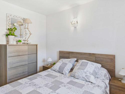 Cette chambre comprend un lit avec deux oreillers et une commode. dans l'établissement Appartement cosy 2 pièces, 4 pers, 30m plage, ascenseur - FR-1-423-203, au Grau-dʼAgde