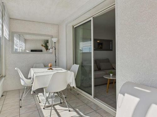 un salon avec une table et des chaises blanches dans l'établissement Appartement cosy 2 pièces, 4 pers, 30m plage, ascenseur - FR-1-423-203, au Grau-dʼAgde