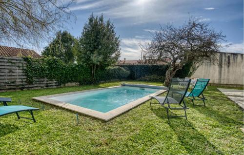 a swimming pool in the yard with two chairs at 3 Bedroom Gorgeous Home In Rochefort in Rochefort