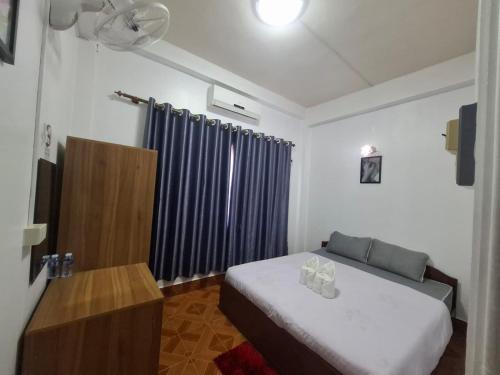 a bedroom with a bed and a blue curtain at vangvieng SCK Hotel in Vang Vieng