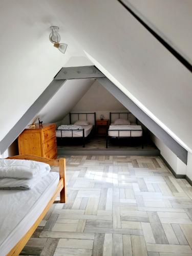 - une chambre mansardée avec 2 lits et un escalier dans l'établissement Gîte des Etourniaux, à La Poterie-Mathieu
